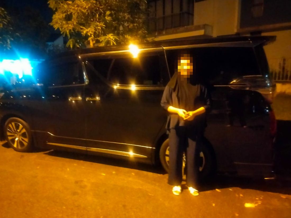 Customer beside the Vellfire outside her home at night