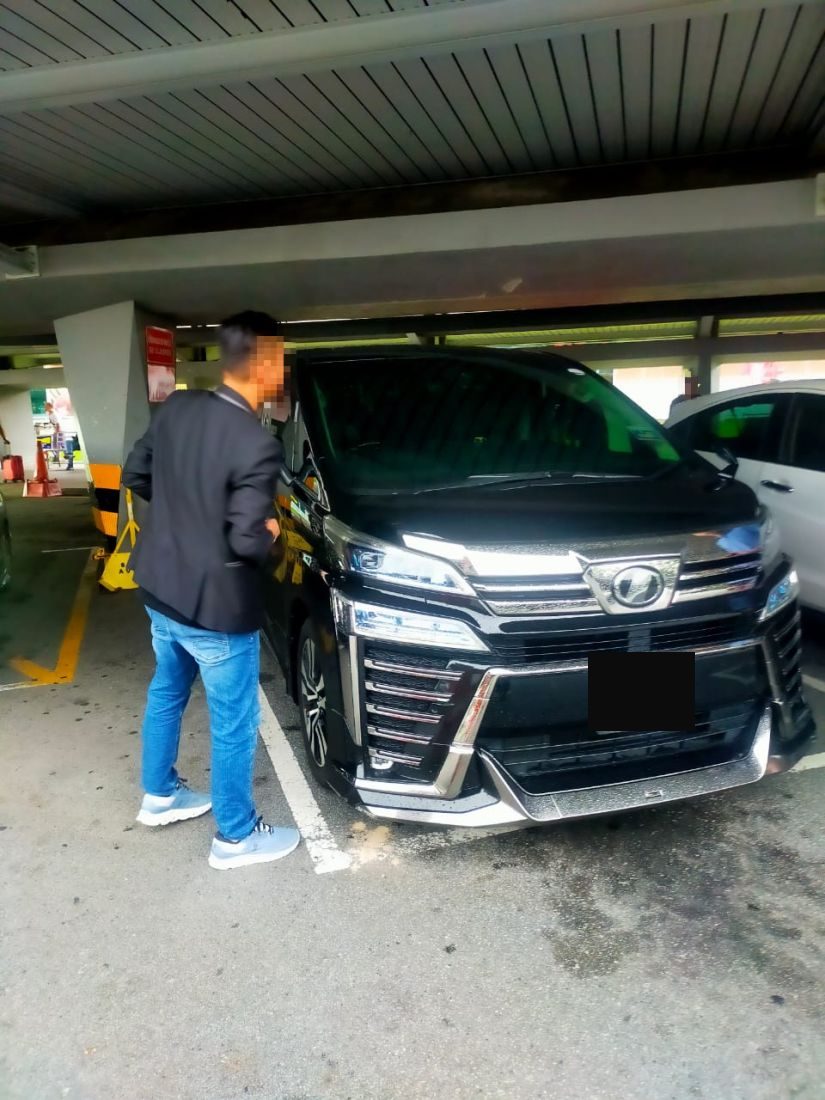 Customer inspecting the Vellfire at a car park